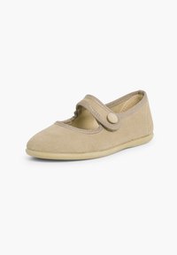 Zapato estilo Mary Jane en color beige con parte superior de ante suave, punta redonda, correa ajustable con botón y suela flexible.