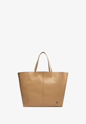 Große beige Leder-Shopper-Tasche mit zwei Tragegriffen und kleinem Metalllogo in der unteren rechten Ecke, vor weißem Hintergrund dargestellt.