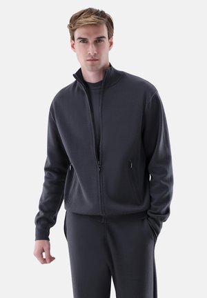 Dark gray zip-up sweatshirt made of soft fabric, featuring a high collar, two front pockets, and ribbed cuffs. Paired with matching pants.