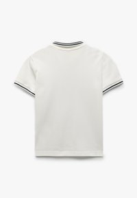 Hvid kortærmet polo-shirt med ribbet krave og marineblå striber i kanten af ærmerne. Glat stoftekstur, afslappet design.
