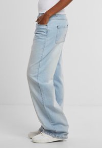 Světle modré džíny s volným střihem, designem s pěti kapsami a mírným vyblednutím. Disponují kovovými nýty a rovnými nohavicemi.