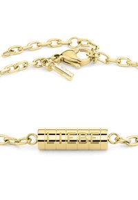 Bracelet en chaîne dorée avec un charm cylindrique gravé des lettres formant le mot "LIEBE", fermeture à fermoir et finition métallique brillante.