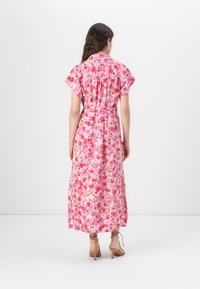 Blomstret maxi-kjole med pink og røde nuancer, korte ærmer, tætsiddende talje og flagrende kant, lavet af letvægtsstof.