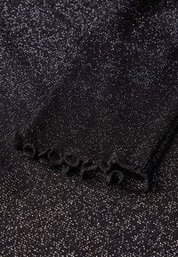 Tessuto nero con scintillii argentati, caratterizzato da un bordo arricciato. La texture appare liscia e leggermente lucida, creando un effetto scintillante.