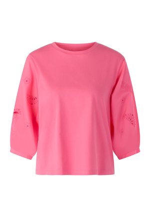 Bright pink long-sleeve top with a round neckline and subtle cut-out floral and fruit patterns on the sleeves.