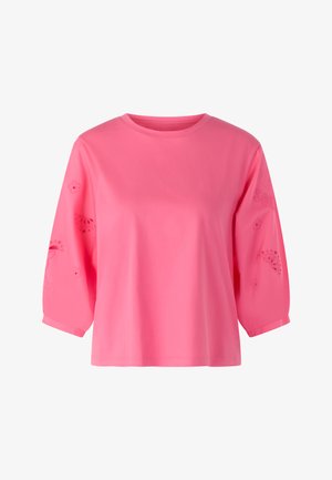 Bright pink long-sleeve top with a round neckline and subtle cut-out floral and fruit patterns on the sleeves.