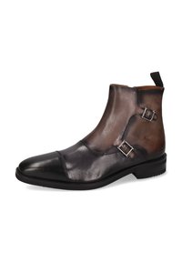 Botines de cuero que presentan un diseño bicolor en marrón oscuro y negro, con hebillas plateadas, punta redondeada y una textura suave.