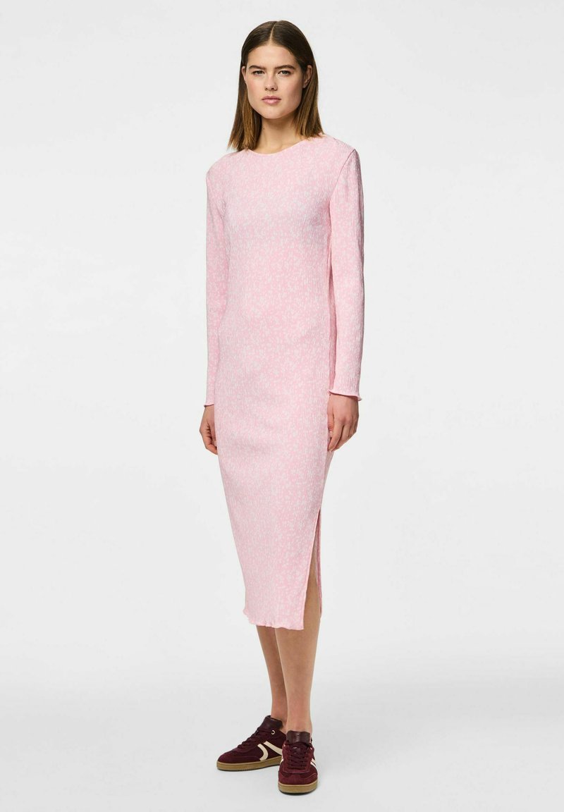 Roza rebrasta obleka dolgih rokavov z odprtinami in teksturiranim vzorcem, v kombinaciji z maroon športnimi copati.