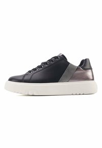 Zapatilla de piel negra con acentos de textil gris y suela de goma blanca. Presenta cordones redondos, un acabado suave y un diseño elegante.