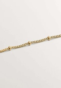 Pulsera de cadena en tono dorado, con eslabones interconectados y cuentas redondas lisas espaciadas uniformemente a lo largo del diseño. Textura elegante y estilo minimalista.