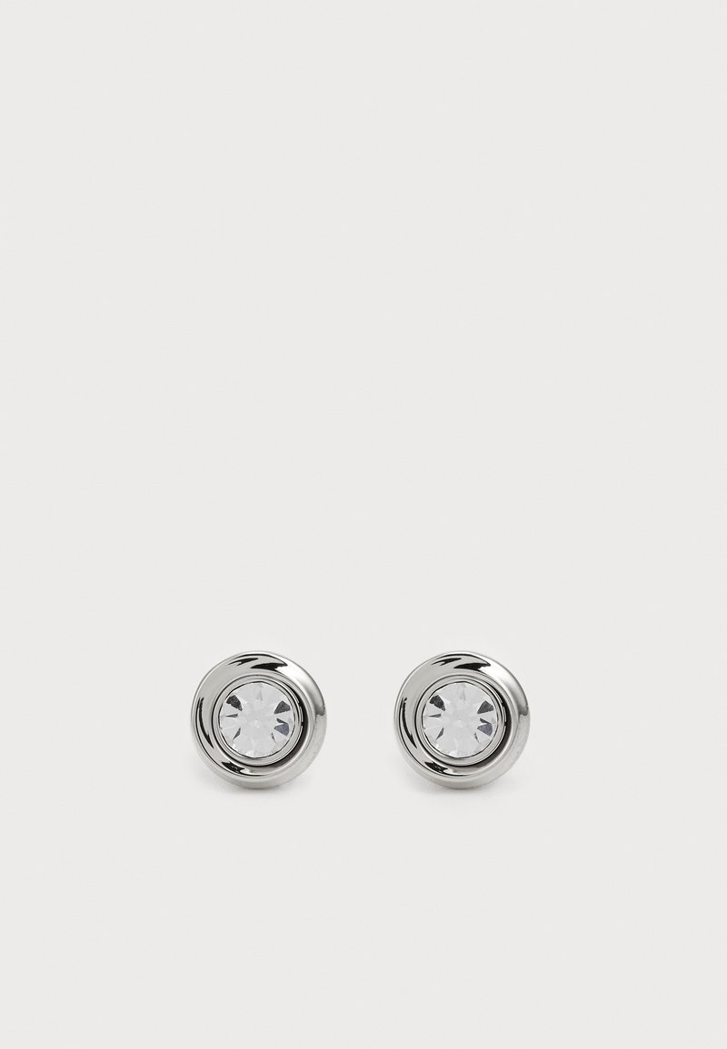 Brincos de metal prateado com pinos, adornados com cristais transparentes redondos, apresentando um acabamento polido suave e um design circular com bordas levemente elevadas.
