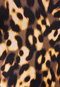 Υφασμα με σχέδιο λεοπάρδαλης, με ακανόνιστα μαύρα και σκούρα καφέ στίγματα σε ανοιχτό καφέ και μπεζ φόντο.