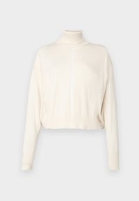 Krēma krāsas īss džemperis ar augstu stāvošu apkakli, ribota rokturiem un apakšmalu. Mīksta tekstūra ar nelielu spīdumu un vertikāliem šuvumiem.