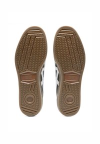 Shoe soles feature a tan rubber material with a wavy tread pattern; black with white accents on the upper side, showing a classic design.