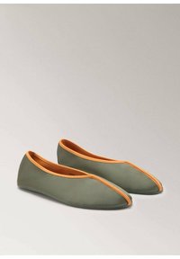 Grüne flache Schuhe mit einer orangefarbenen Akzentuierung, die ein schlankes Design und eine glatte Textur aufweisen, geeignet für die Freizeit.