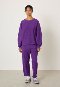 Vijolična, mehke teksture, dolgosleeve pulover, v kombinaciji z ujemajočimi se hlačami, z sproščenim krojem in preprostim krožnim izrezom.
