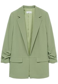 Blazer vert clair pour femme avec revers crantés, deux poches à rabat à l'avant et manches longues froncées.