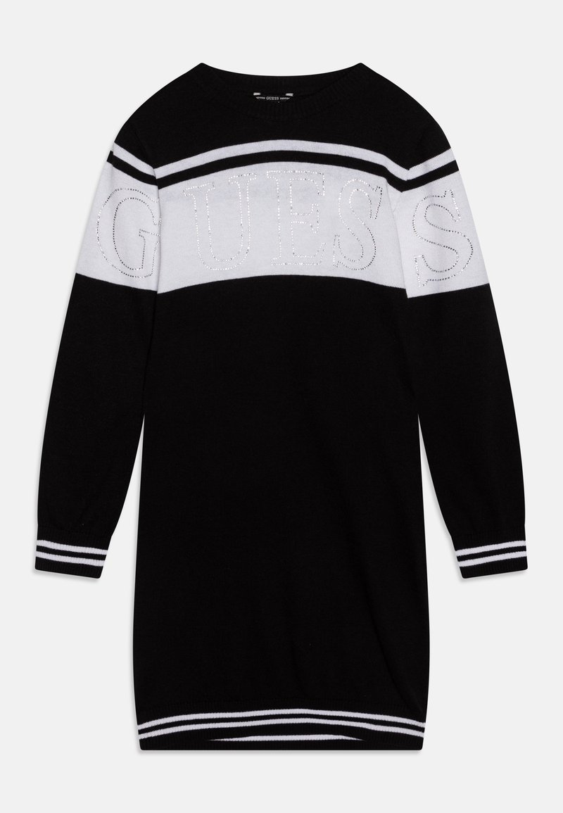 Robe en maille à manches longues noire avec des rayures horizontales blanches et un logo "GUESS" orné de strass sur la poitrine et les manches supérieures.