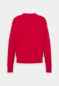 Sweat-shirt rouge à manches longues et col rond vu de dos, avec des poignets et un ourlet côtelés, sur un fond clair uni.