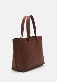 Brown leather tote bag with two handles, featuring a smooth texture, contrasting stitching, and a spacious interior.