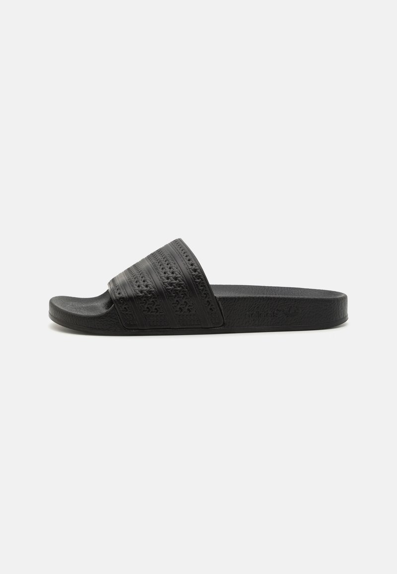 Black slide sandal featuring a textured strap with horizontal ridges, a durable footbed, and a flat sole for comfort.