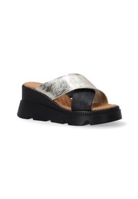Zwarte platform sandaal met een zilveren metallic kruisband en geperforeerde tan binnenzool. Beschikt over een gestructureerde rubberen zool voor grip.