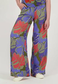 Wijde broek met een levendig bloemenpatroon in rode, blauwe en groene tinten. Gemaakt van lichte stof met een soepele textuur.