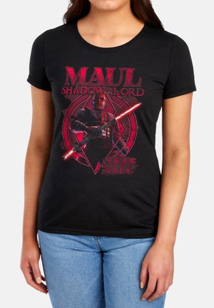 Frau trägt schwarzes T-Shirt mit rotem Motiv von Darth Maul, der ein doppelklingiges Lichtschwert hält, und Text „Maul Schattenherrscher Angst ist mein Verbündeter.“