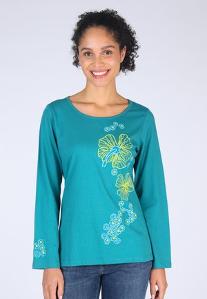 Türkiser Langarmshirt mit floralen Stickereien in Gelb und Blau. Runder Ausschnitt, weicher Stoff und dekorative Muster an Ärmeln und Vorderseite.