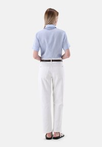 Light blue short-sleeve shirt with a folded collar, paired with white straight-leg pants and a brown belt. The outfit is completed with black sandals.