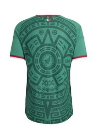 Green short-sleeve shirt with red and white trim, featuring a large dark Aztec calendar pattern on the back and a small logo at the neck.
