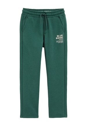 Pantaloni sportivi verdi realizzati in tessuto morbido, con vita elastica, cordoncino, tasche laterali e testo stampato sulla coscia sinistra.