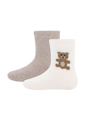 Two toddler socks, one beige and one white with a brown teddy bear design on the side.