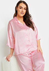 Conjunto de pijama de satén rosa con rayas verticales blancas, parte superior con cuello y botones, mangas de 3/4, y pantalones holgados a juego.