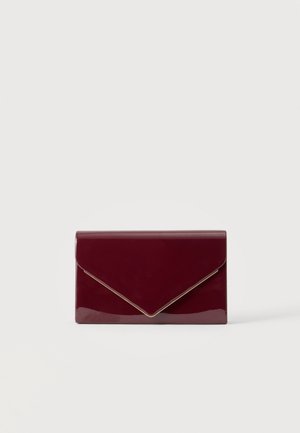 Pochette rouge foncé brillante de style enveloppe avec bordure dorée le long du bord du rabat sur un fond clair uni.