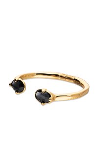 Brazalete de metal con tono dorado que presenta dos piedras facetadas negras en cada extremo, con una textura suave y pulida y un detalle de acento en espiral.