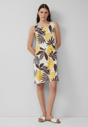 Robe sans manches blanche avec un imprimé de feuilles coloré en jaune et marron. Dotée d'un col rond et de poches latérales.