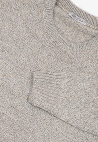 Hellsilberner Strickpullover mit rundem Kragen, der ein texturiertes Muster und gerippte Bündchen aufweist. Der Stoff zeigt subtile Sprenkel von Creme und Beige.