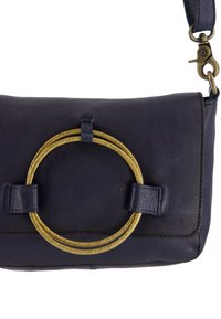 Marineblaue Leder-Schultertasche mit strukturierter Oberfläche, ausgestattet mit einem markanten goldenen kreisförmigen Hardware-Detail und zwei seitlichen Trägern.