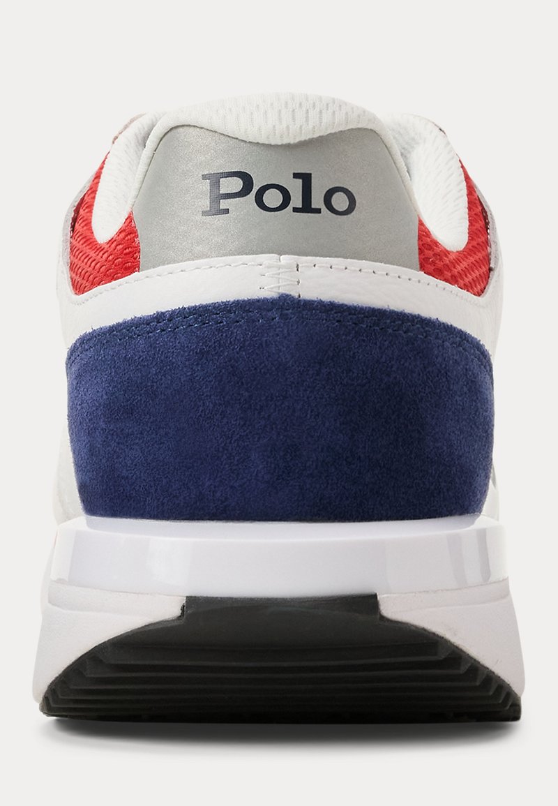 Vue arrière d'une chaussure Polo avec un mesh rouge, un talon en daim bleu marine, une semelle intermédiaire blanche et une semelle extérieure noire.