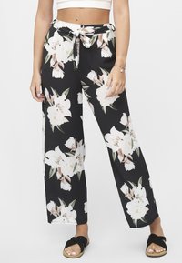 Svarte vidbenbukser med et blomstermønster i rosa og hvite blomster. Har knytebånd i livet og lett stoff.