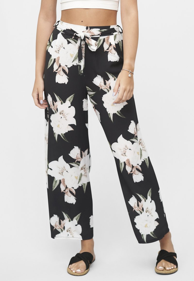 Svarte vidbenbukser med et blomstermønster i rosa og hvite blomster. Har knytebånd i livet og lett stoff.