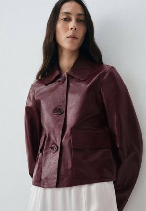 Giacca in pelle bordeaux con colletto a punta, chiusura a cinque bottoni e due tasche frontali. Texture liscia, design accorciato e stile minimalista.