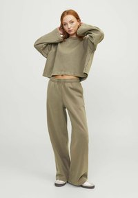 Olijfgroene cropped sweatshirt met lange mouwen, gecombineerd met bijpassende hoge taille wijdvallende broek, beide gemaakt van zachte stof.
