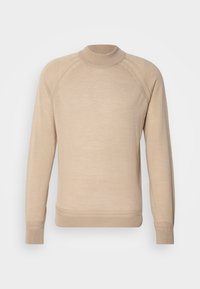 Pull beige à manches longues avec col montant et poignets et ourlet côtelés, présentant des coutures raglan aux manches.