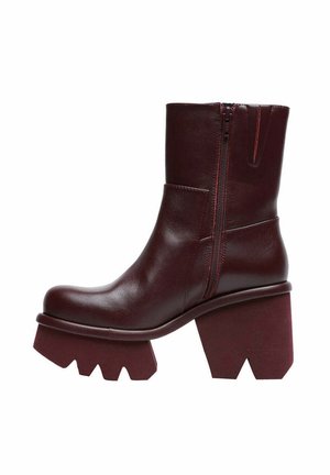 Stivali alla caviglia borgogna realizzati in pelle liscia, con zip laterale, tacco angolare spesso e suola piattaforma con un design zigzag unico.