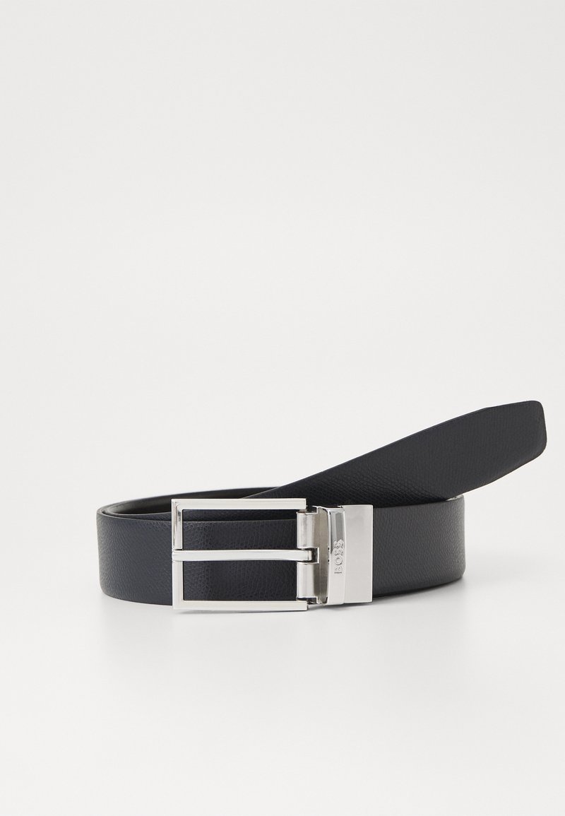 Čierny kožený opasok s obdĺžnikovou striebornou kovovou sponou, ktorá má textúrovaný povrch a plochý, hladký pás.