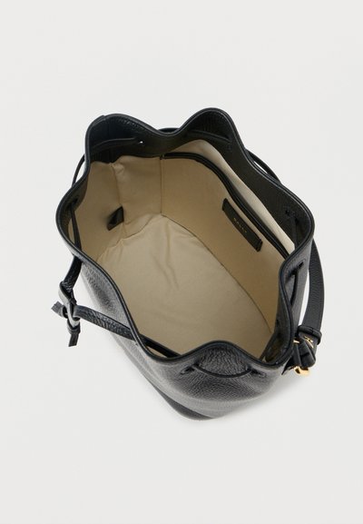 Μαύρη δερμάτινη τσάντα τύπου bucket με μπεζ υφασμάτινο εσωτερικό, διαθέτει εσωτερική τσέπη με φερμουάρ και ρυθμιζόμενο ιμάντα με χρυσή αγκράφα.