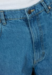 Jean de mezclilla azul con una cintura alta, cierre de botón metálico y costuras doradas. Textura suave, con un diseño clásico de cinco bolsillos.