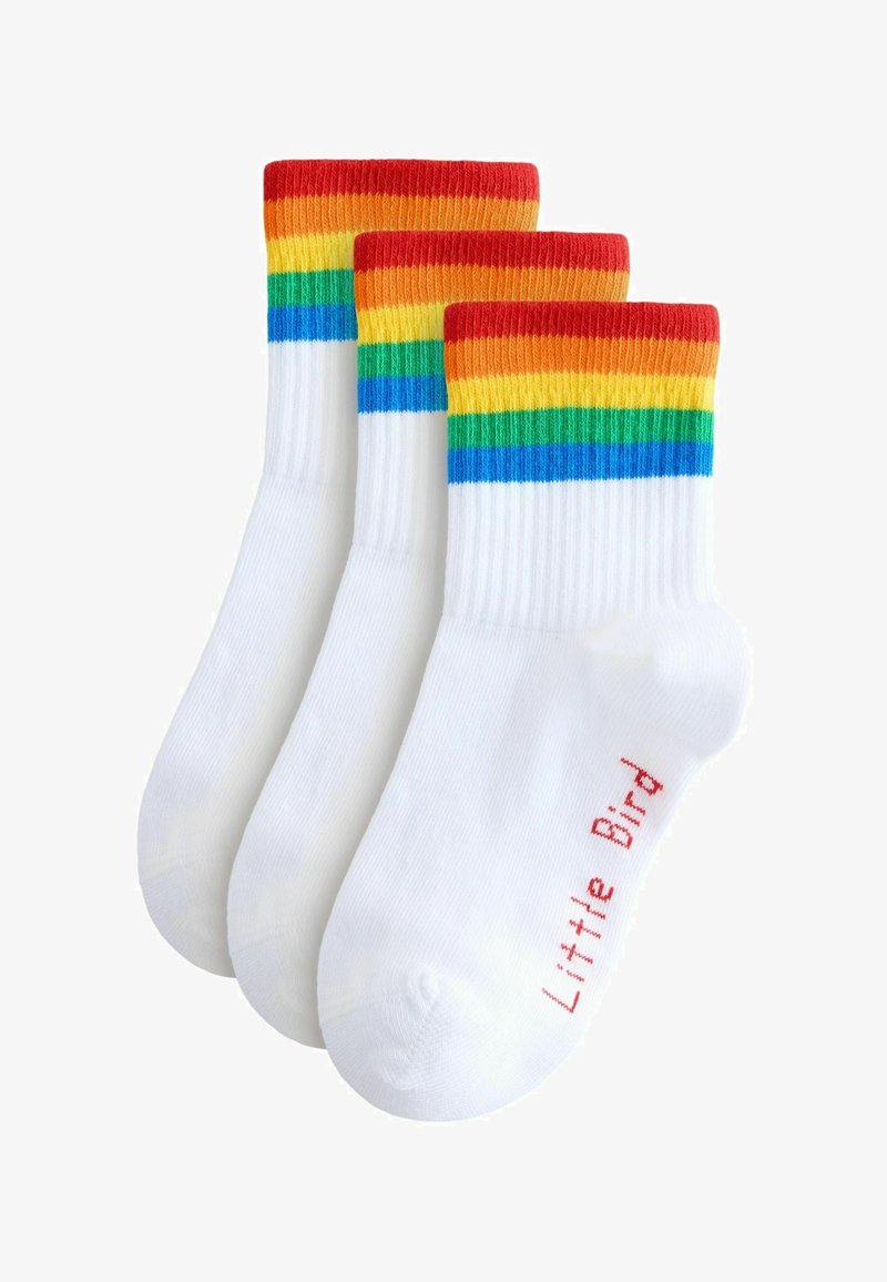 Chaussettes en coton blanc avec des bordures rayées rouges, oranges, jaunes, vertes et bleues. Présentent le texte « Little Bird » en rouge sur le côté.